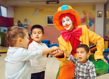 Children greeting their teacher at the classroom door in the morning